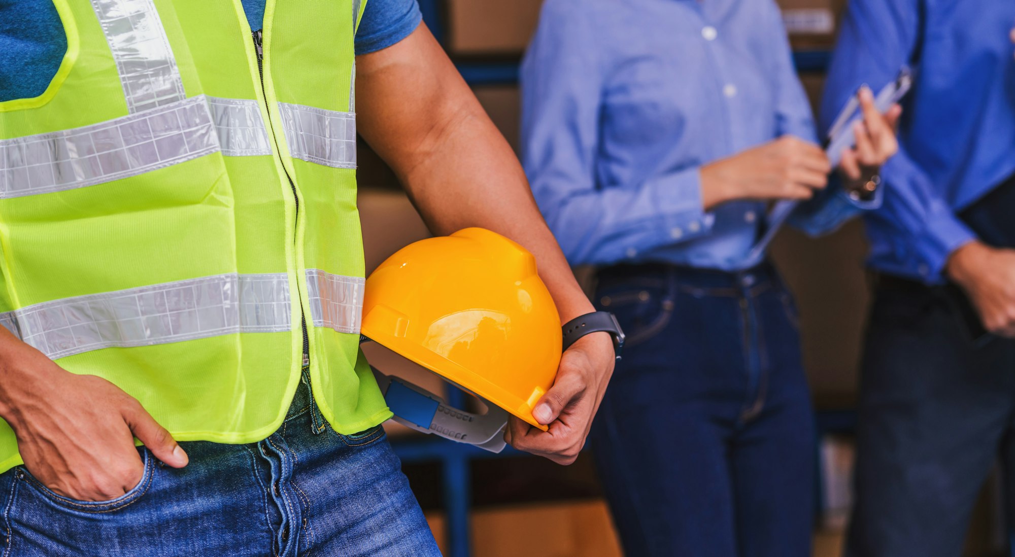 Closeup Indian Worker man hand holding safety helmet over White Caucasian Manager